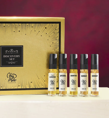 Set of perfume bottles with a gold box labeled 'Discovery Set' on a red background