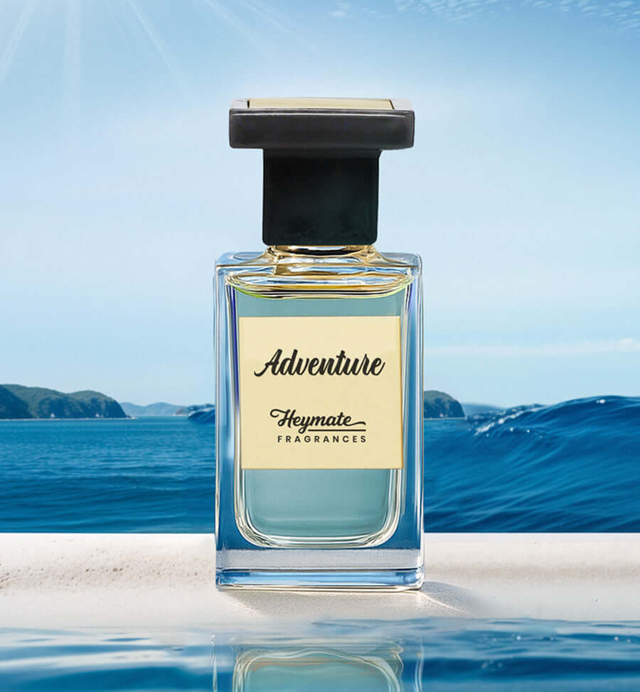 Perfume bottle labeled 'Adventure' by Heymate Fragrances with a scenic background of water and sky.