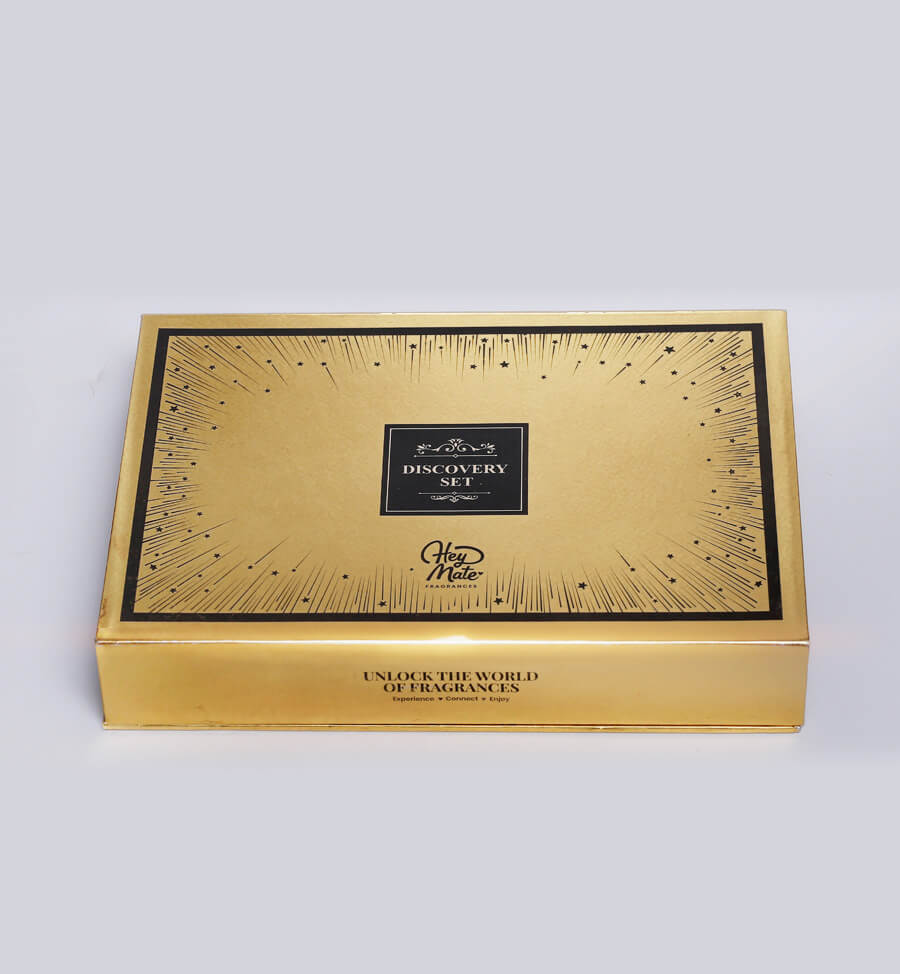 Gold and black fragrance discovery set box on a white background