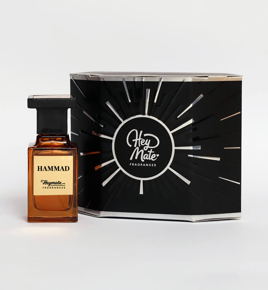 Perfume bottle labeled 'Hammad' by Hey Mate Fragrances next to its packaging on a white background