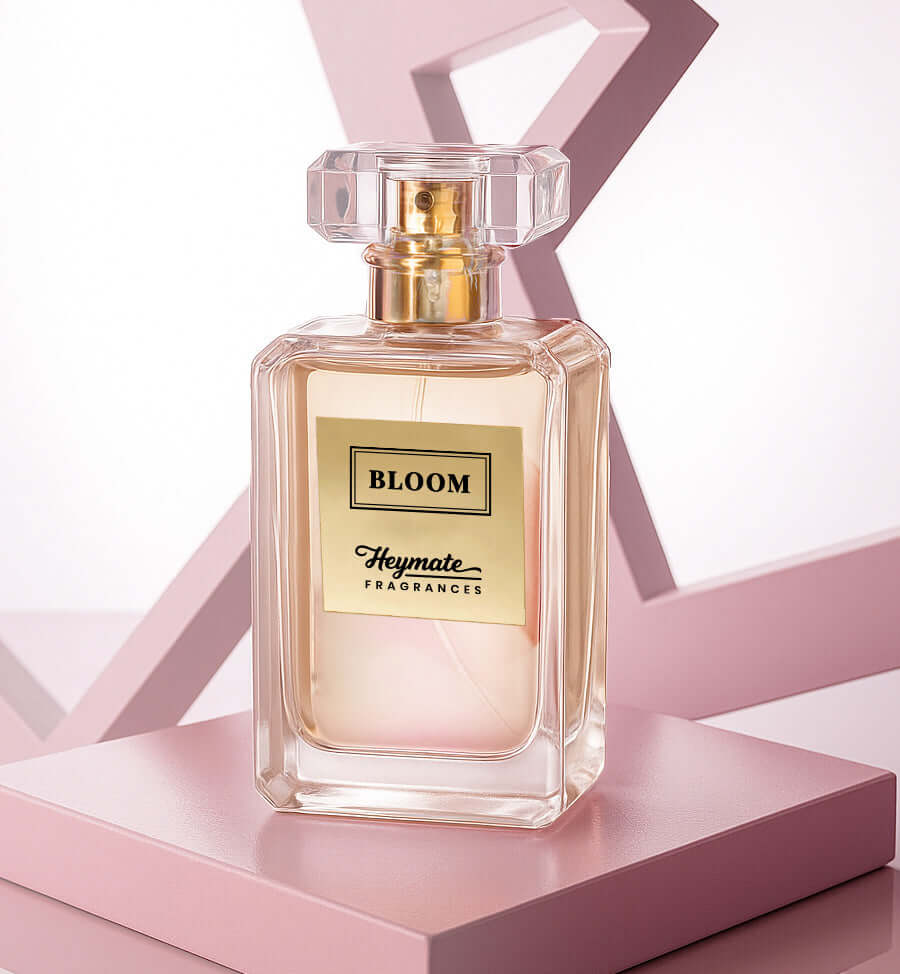 Perfume bottle labeled 'Bloom' by Heymata Fragrances on a pink geometric background
