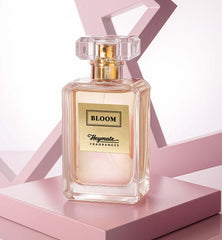 Perfume bottle labeled 'Bloom' by Heymata Fragrances on a pink geometric background