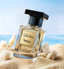 Perfume bottle labeled 'Blue Horizon' by Heymate Fragrances on a sandy beach with shells.