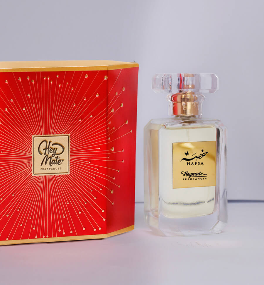 Perfume bottle and red box with 'Hey Mate' branding on a light gray background