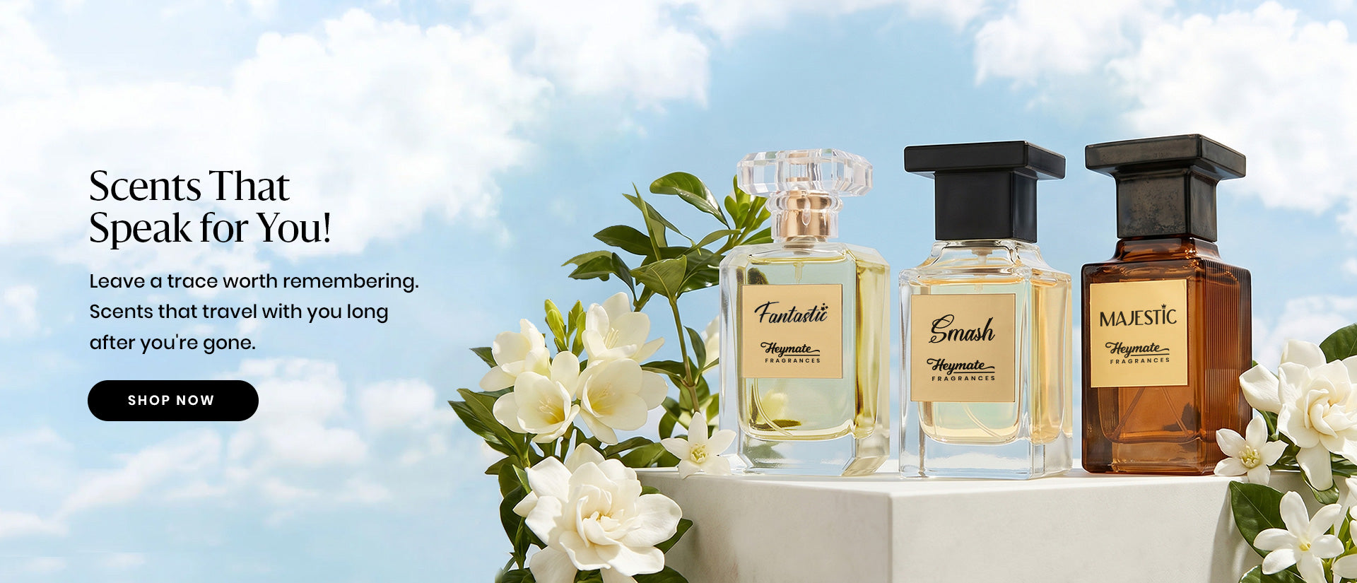 Three perfume bottles on a Podiom with flowers against a blue sky background
