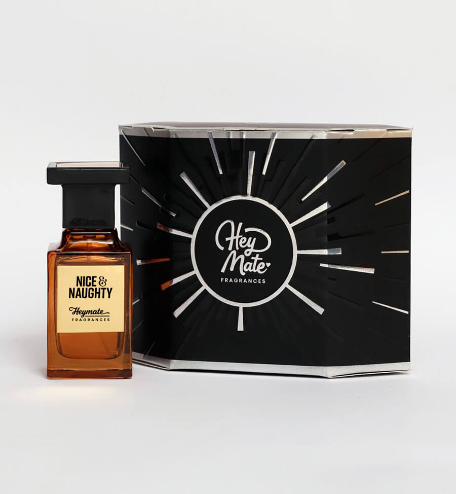 Perfume bottle labeled 'Nice & Naughty' by Hey Mate Fragrances next to its packaging on a white background.