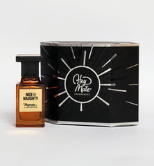 Perfume bottle labeled 'Nice & Naughty' by Hey Mate Fragrances next to its packaging on a white background.