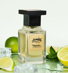 Perfume bottle labeled 'Sunday for Men' with limes and mint leaves on a light background